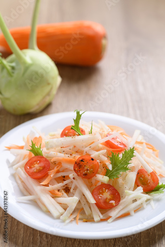 Salad with sliced kohlrabi, carrot, tomato and mizuna leaf on white dish, Vegan food, Healthy eating