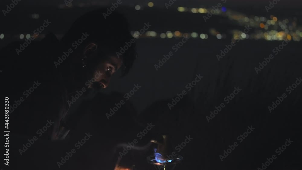 A bearded man preparing a traditional turkish coffee in a finjan coffee pot at night. Slow motion. A bearded man preparing a traditional turkish coffee in a finjan coffee pot at night. Slow motion.