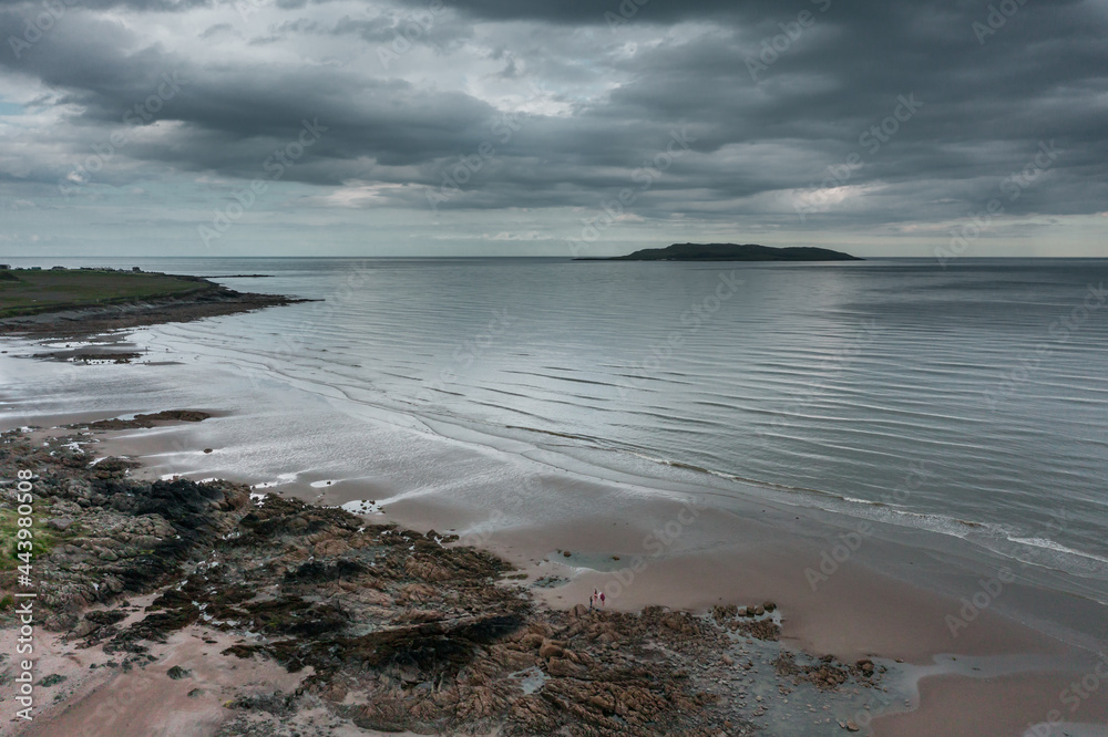 Aerial view over beach landscape and revealing the Irish sea and Lambay Island on a cloudy evening Donabate beach in summer, Dublin, Ireland	
