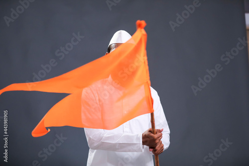 Young indian man (pilgrim) in traditional wear and waving religious flag. photo