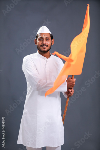 Young indian man (pilgrim) in traditional wear and waving religious flag. photo