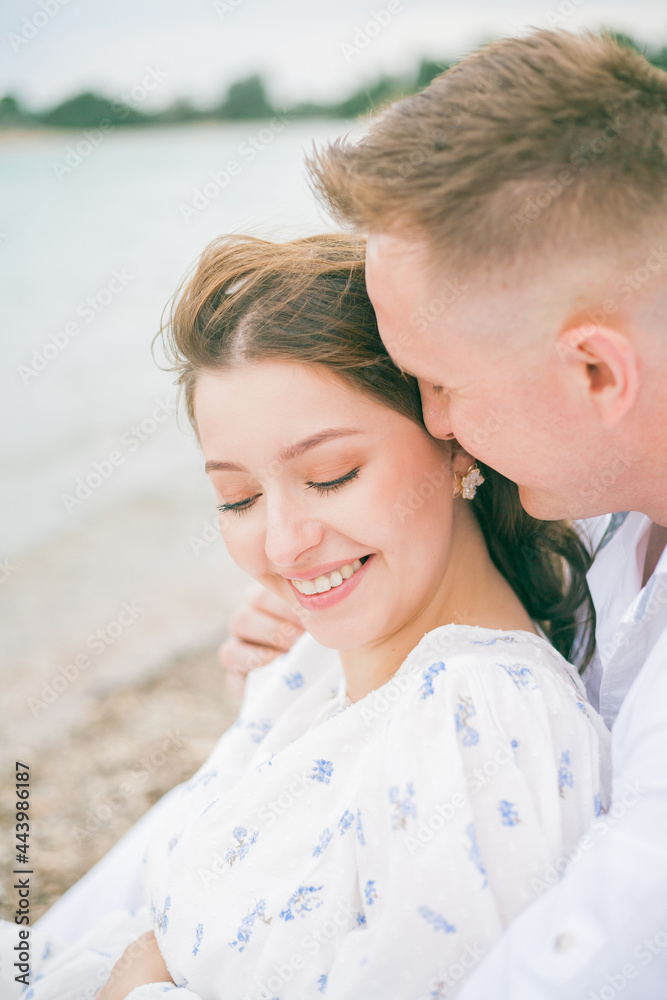 Young beautiful couple in anticipation of the baby near the sea. Pregnancy. Picnic. Summer. Young beautiful couple in anticipation of the baby near the sea. Pregnancy. Picnic. Summer.