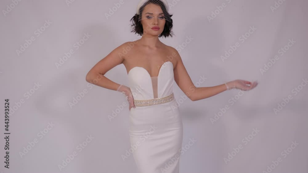Portrait of an elegant bride in a short dress and a short veil in the studio. Portrait of an elegant bride in a short dress and a short veil in the studio.