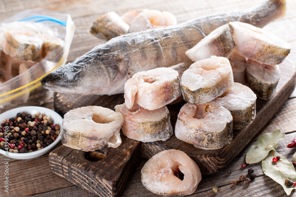 Fototapeta premium Frozen fish on a cutting board on a table. Frozen food