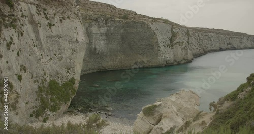 Fomm Ir-Rih Bay, Malta Island. Static View, Steep Cliffs Above Mediterranean Sea Lagoon. Scenic Coastline on Cloudy Day photo