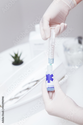 Vertical cropped shot of manicurist filling syringe with sanitizer for disinfectant liquid © Ihor