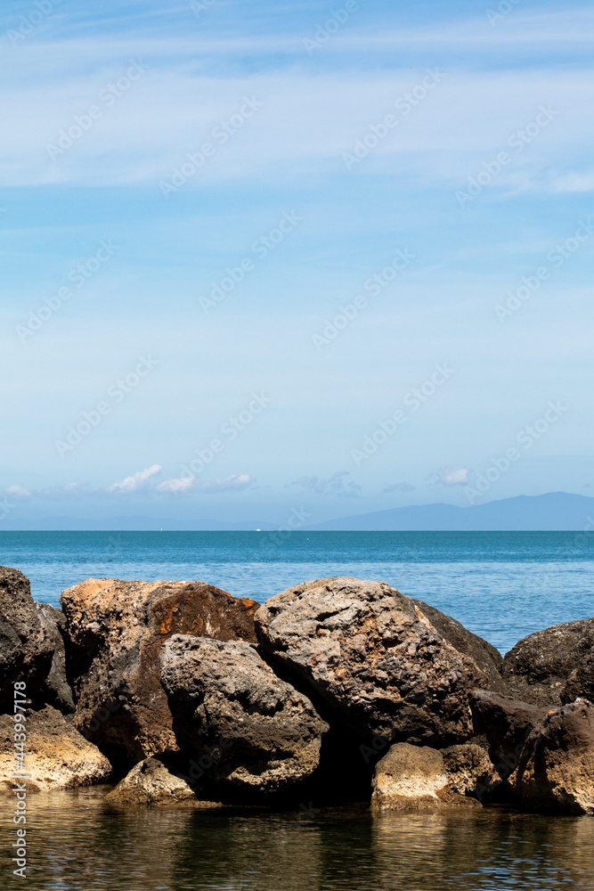 Sea and rock background. Rock and blue sea with clear sky. Seaside travel destination background image. Clear blue sea and blue sky in summertime Sea and rock background. Rock and blue sea with clear sky. Seaside travel destination background image. Clear blue sea and blue sky in summertime