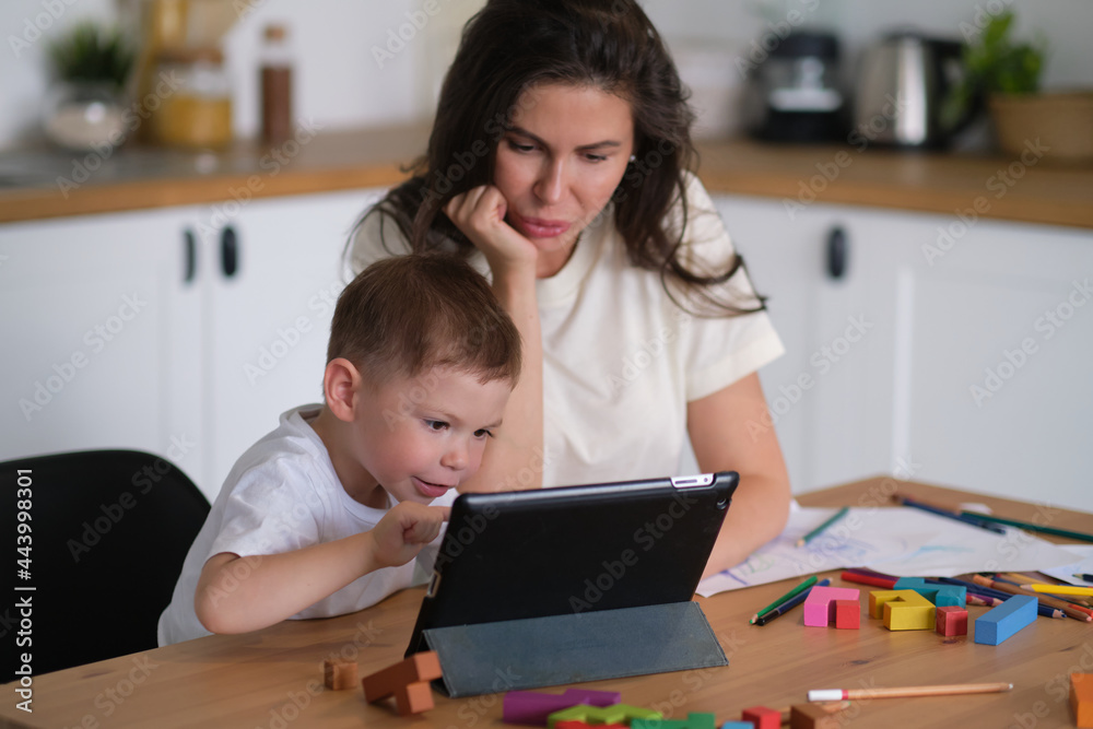 Mother with young boy using digital tablet.happy mom and baby play educational online games on the tablet.