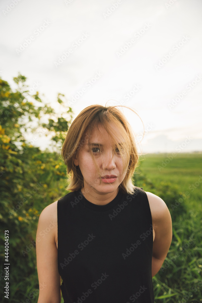 Young attractive asian woman in black dress on the field at sunset. Young attractive asian woman in black dress on the field at sunset.