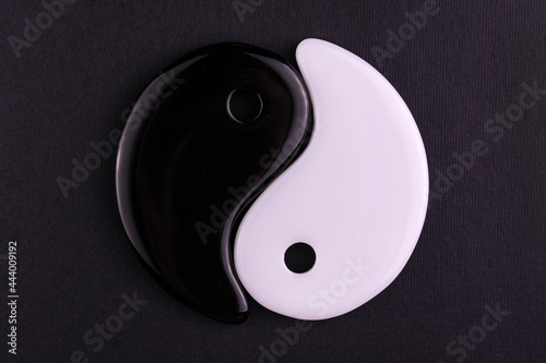 Japanese symbol of masculine and feminine beginning yin yang on a black background.