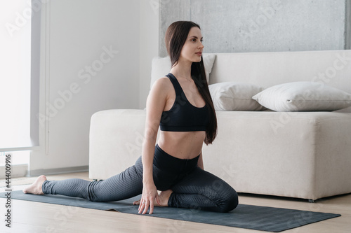 Beautiful woman warming up body muscles at home