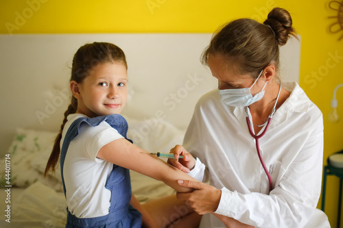 nurse in mask and white coat injects child girl with syringe  calling doctor at home  patronage. Treatment of pediatrician at home in real interior  concept of medicine and disease prevention