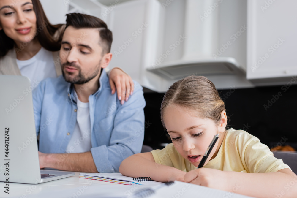 blurred woman smiling near husband and daughter writing in notebook blurred woman smiling near husband and daughter writing in notebook
