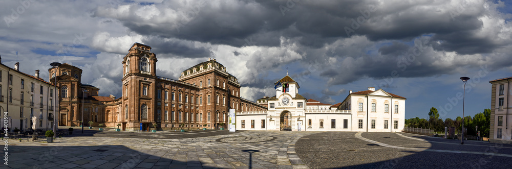 Venaria Reale, Piedmont, Italy. July 2021. Large format panoramic photo of the piazza della repubblica. Highlights the clock tower: entrance to the royal palace. Beautiful summer day.