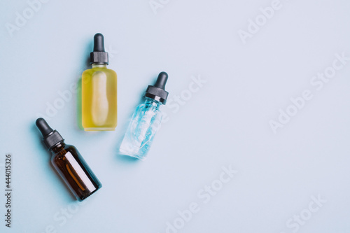 Cosmetic products gel serum lubricant hyaluronic acid with oxygen bubbles glass vials with a pipette blue background