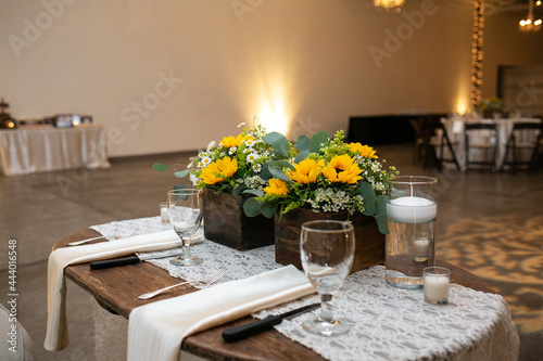 private table set for bride and groom at wedding reception with yellow flowers