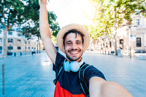 Photography Happy tourist man taking selfie with smart phone device on city street - Smiling