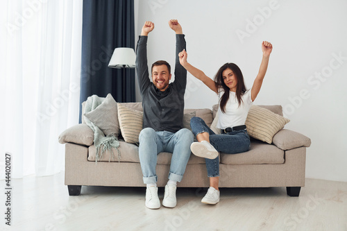 Happy owners of a new apartment is sitting on the sofa