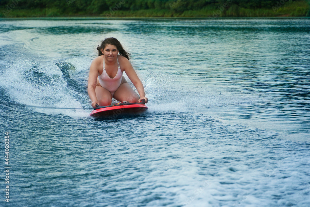 Young woman On Wakeboard. Awesome summer water sport and resting. Wakeboarding.
