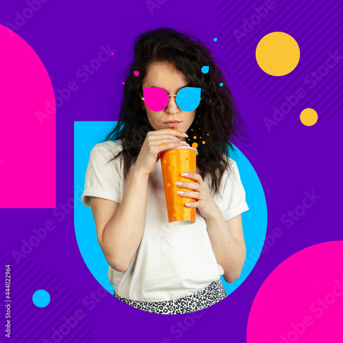Creative image, art collage. Portrait of young caucasian girl in multicolored glasses with paper cup over purple background. photo