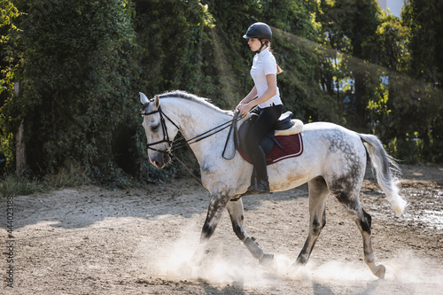 Young girl rides her horse in a nature.