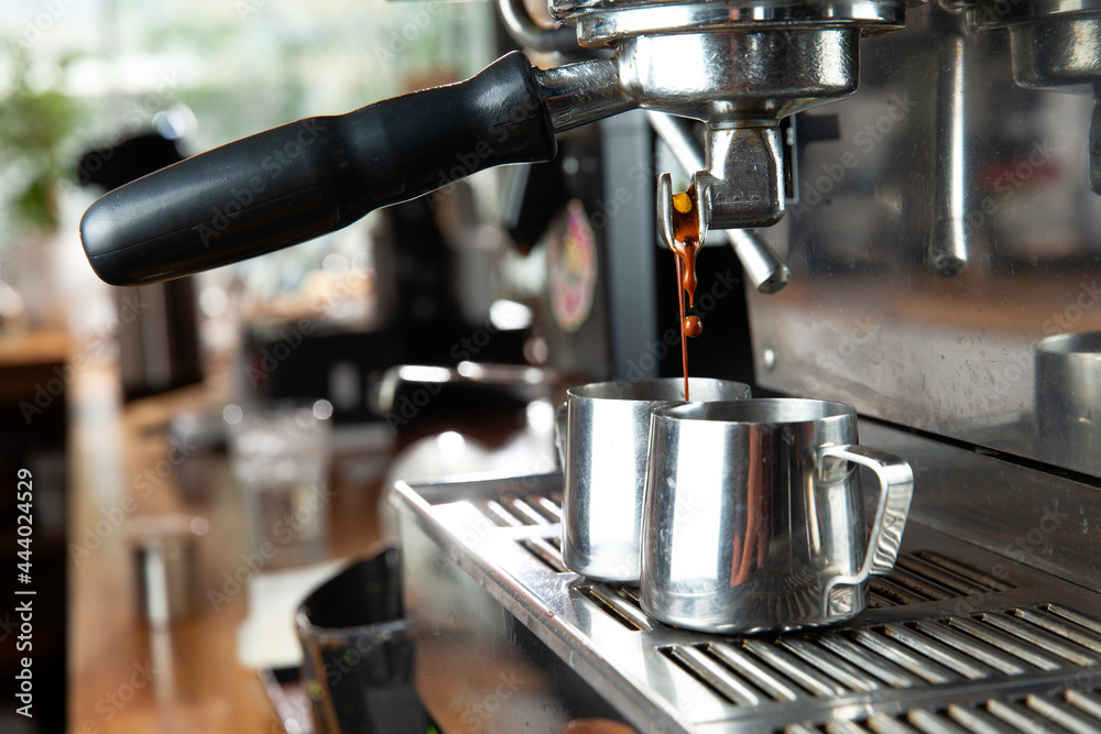 Makes coffee. A coffee machine pours coffee into a pitcher. Makes coffee. A coffee machine pours coffee into a pitcher.