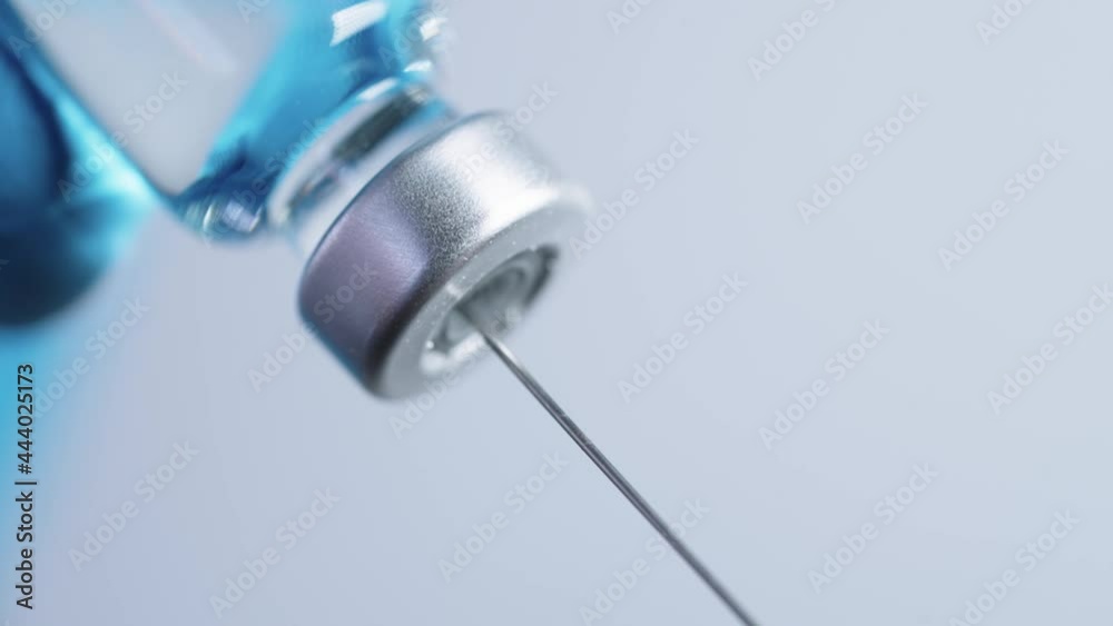 closeup on needle inserting into vaccine vial slowly, doctor's with surgical gloves sucking mRNA vaccine out of bottle for building the herd immunity in country, coronavirus epidemic prevention, closeup on needle inserting into vaccine vial slowly, doctor's with surgical gloves sucking mRNA vaccine out of bottle for building the herd immunity in country, coronavirus epidemic prevention,