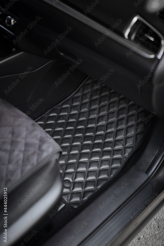 Car floor mat with diamond pattern. Ecoleather dark floormat on the second row in the modern vehicle. transmission tunnel on the passenger seat site in the vehicle. concept of luxury and clean car