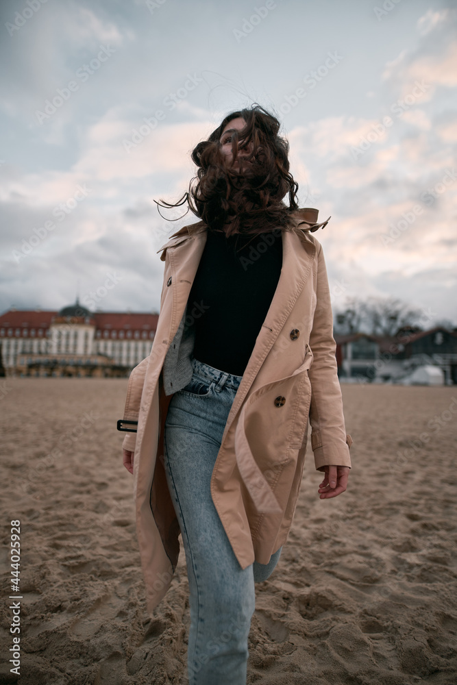 Lifestyle Portrait Of Brunette Wears Trench Coat Black Shirt And Jeans
