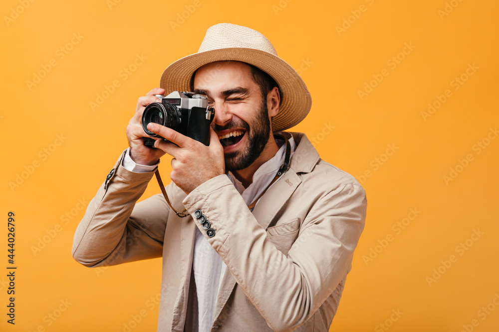 Cheerful guy in beige outfit takes photos on camera Cheerful guy in beige outfit takes photos on camera
