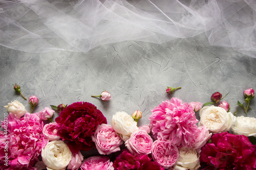 paeonia and roses floral pattern with bridal veil on gray concrete background. Wedding template for invitation