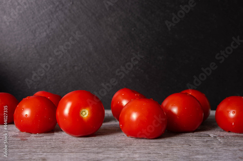 washed ripe tomatoes on black background