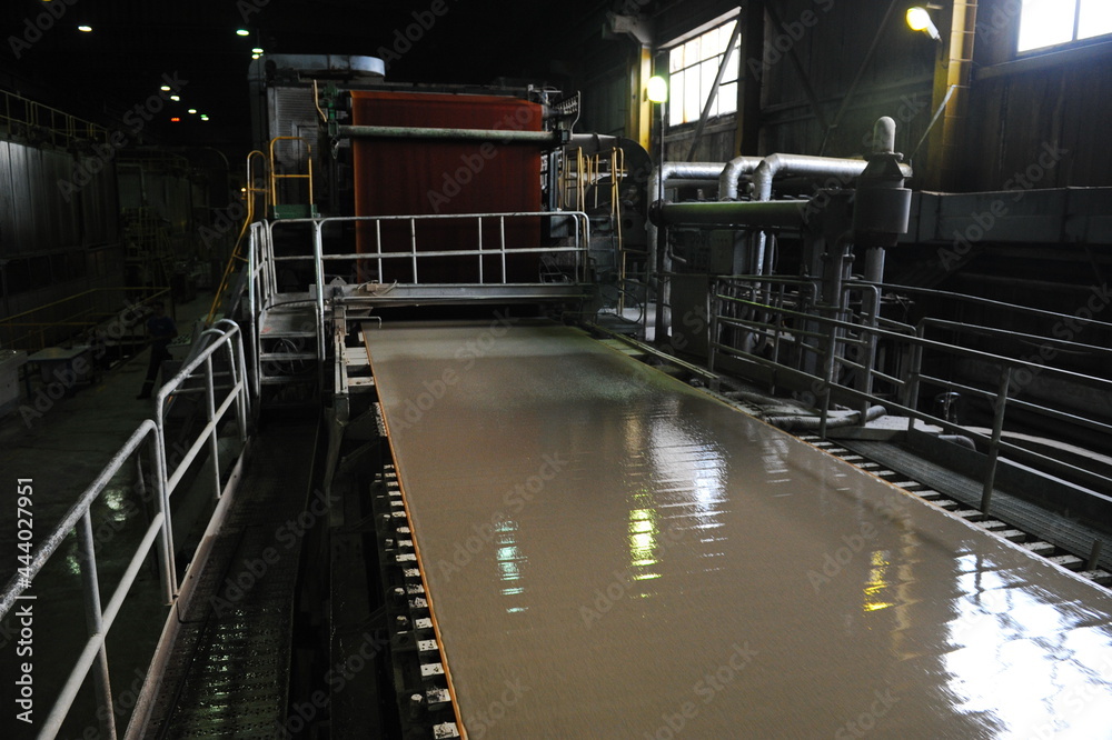 Almaty, Kazakhstan - 07.01.2016 : Conveyor belt with a liquid mixture for the production of cardboard at the factory.