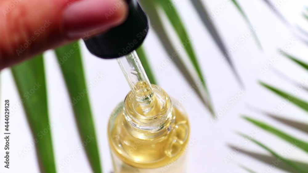 Serum oil is dripping from dropper close-up. Serum skin care product. Selective focus
