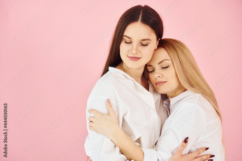 Portrait of young mother with her daughter that standing in the studio Portrait of young mother with her daughter that standing in the studio