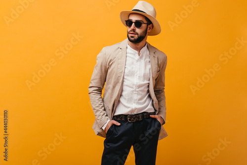 Portrait of guy in sunglasses dressed in suit and hat photo