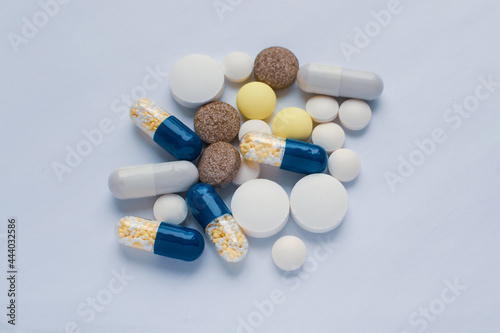 Tablets and pills on the white table, consuming a lot of pills concept