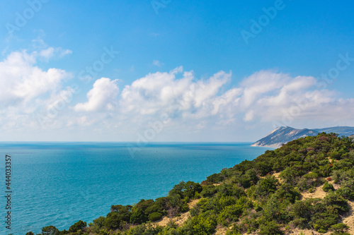 Anapa, Russia - June 11, 2021: Stony beach of Black Sea coast in Bolshoy Utrish village full of people on bright sunny summer day. Aerial view.