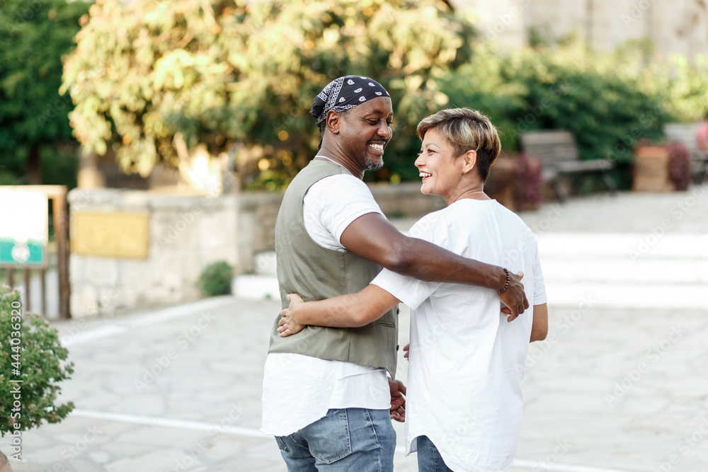 Fototapeta premium Mixed race smiling couple enjoying on vacation, tourist having fun walking and exploring city street during the day. holidays in diversity and love concept.