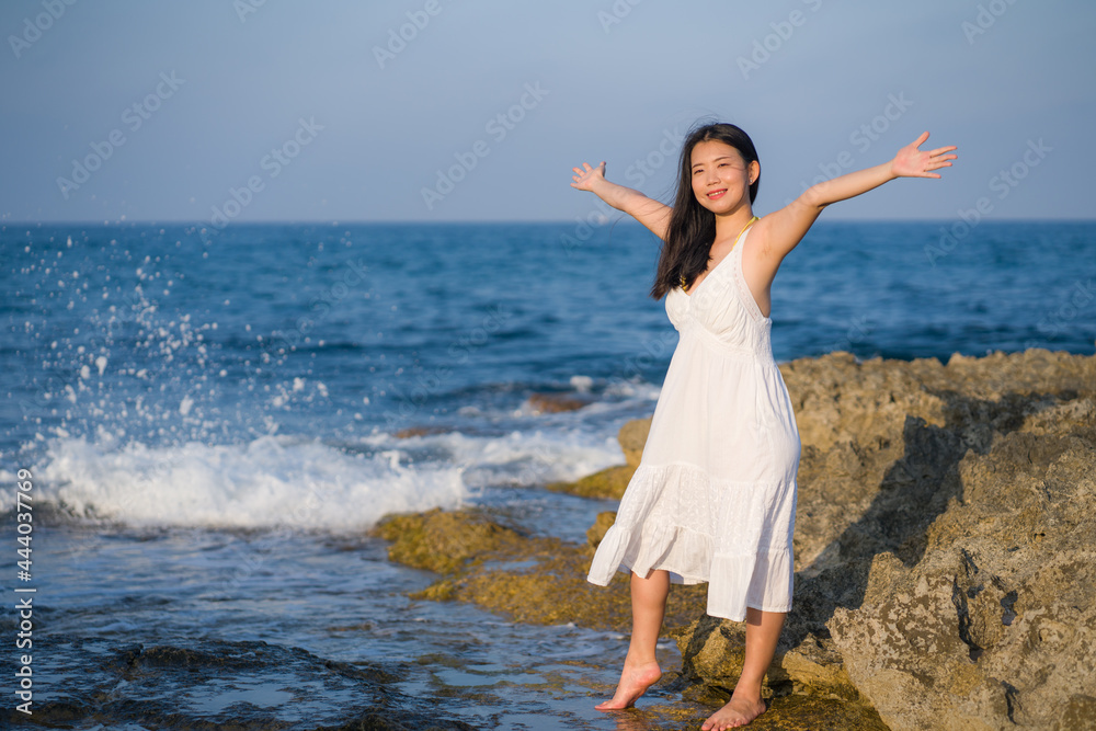 summer lifestyle portrait of young beautiful and happy Asian woman at the beach - Attractive Korean girl by the sea enjoying holidays trip on rock cliff with ocean view summer lifestyle portrait of young beautiful and happy Asian woman at the beach - Attractive Korean girl by the sea enjoying holidays trip on rock cliff with ocean view