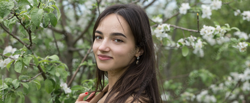 Portrait of a positive cheerful brunette girl in a green spring park Portrait of a positive cheerful brunette girl in a green spring park