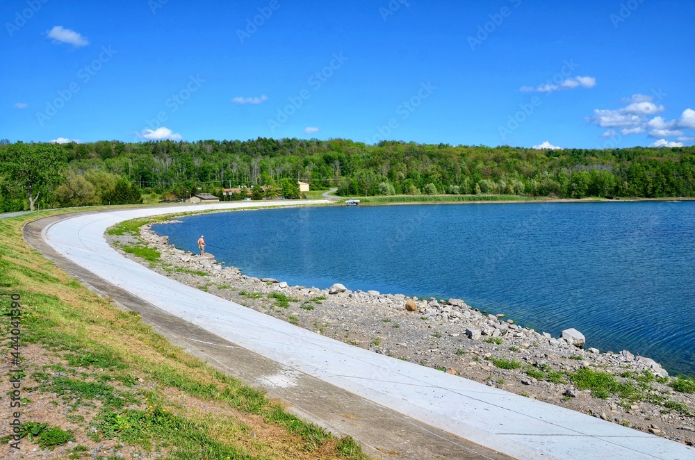 Hemlock Lake with curved dam, one of the minor Finger Lakes. It is mostly located in Livingston County, New York, south of Rochester. It’s forever-wild, tranquil landscape the perfect place to unwind