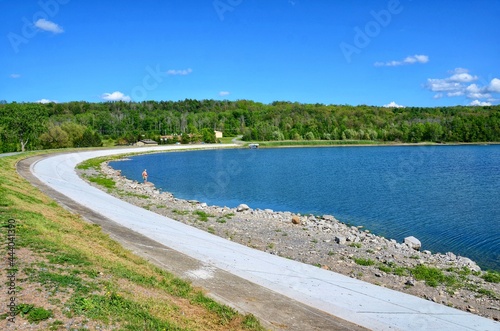 Hemlock Lake with curved dam  one of the minor Finger Lakes. It is mostly located in Livingston County  New York  south of Rochester. It   s forever-wild  tranquil landscape the perfect place to unwind