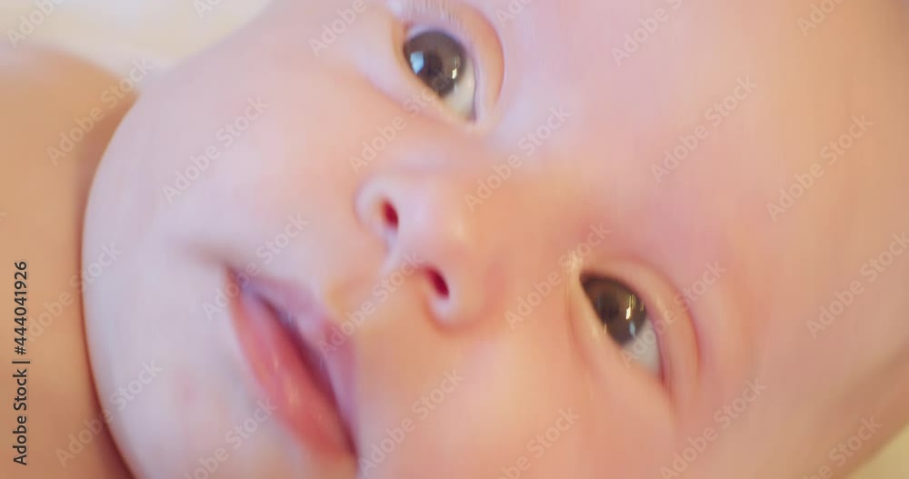 portrait of a cute little baby lying in bed. close-up. view from above.