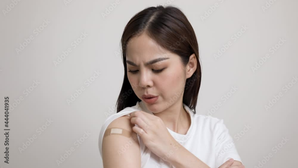 Young beautiful asian woman feel pain in arm after receiving the vaccine. She was worried and stressed that there would be side effects. She tried to massage her aching arm. Young beautiful asian woman feel pain in arm after receiving the vaccine. She was worried and stressed that there would be side effects. She tried to massage her aching arm.