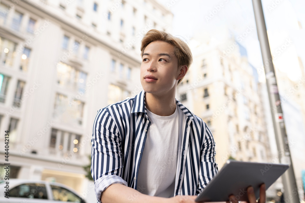 Asian man using tablet in city Asian man using tablet in city