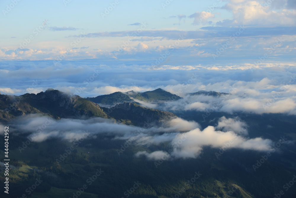 Entlebuch on a morning after rainfall. Clouds and fog lifting over green hills and mountains.
