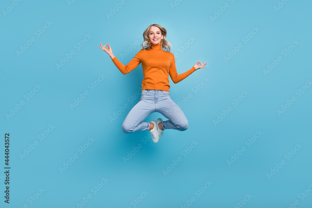 Full body photo of cheerful young positive woman jump up asana om signs isolated on blue color background