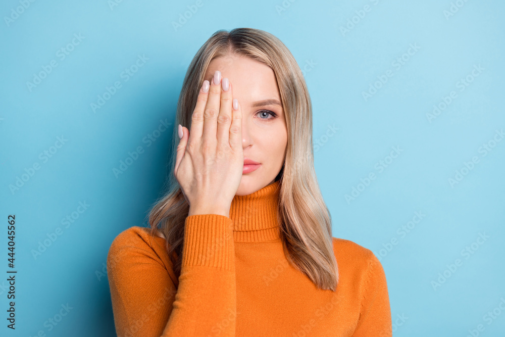 Photo of charming sweet young woman dressed orange pullover arm cover half face isolated blue color background Photo of charming sweet young woman dressed orange pullover arm cover half face isolated blue color background