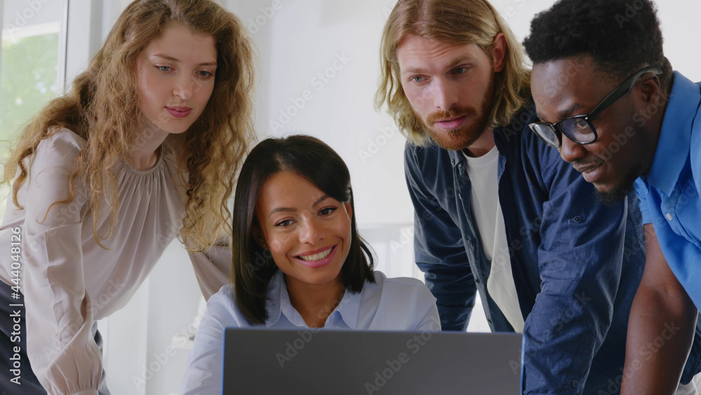 Group of young confident business people analyzing data using computer